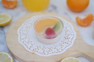 Fruit jelly with orange juice, lemon and kiwi on the table photo