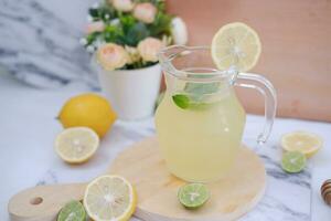 Lemonade with fresh lemon and mint leaves on a white background photo