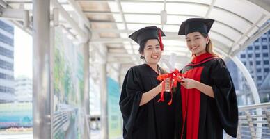 feliz estudiante graduado mano sosteniendo diplomas y monedas de premio de oro. foto