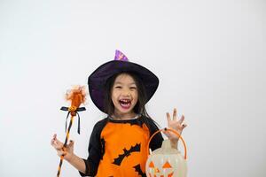 gracioso niño niña en bruja disfraz para Víspera de Todos los Santos con calabaza y bruja escoba. foto