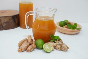 Ginger juice with fresh ginger and lemon on white background. Healthy drink. photo