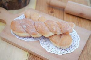 Bread donuts on the wooden table with wooden rolling pin. photo