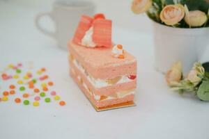 Piece of cake and cup of tea on white background, stock photo