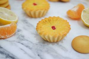 Lemon tartlets with fresh lemons and tangerines. photo