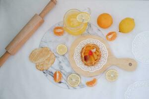 hecho en casa limón tarta con Fresco Fruta y naranja jugo en blanco antecedentes foto