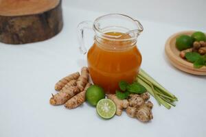 Ginger juice with fresh ginger and lemon on white background. Healthy drink. photo