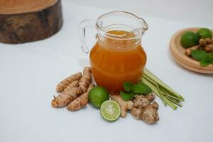Ginger juice with fresh ginger and lemon on white background. Healthy drink. photo