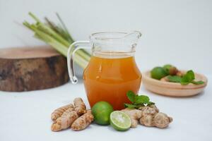 Ginger juice with fresh ginger and lemon on white background. Healthy drink. photo