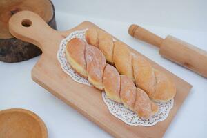 Bread donuts on the wooden table with wooden rolling pin. photo