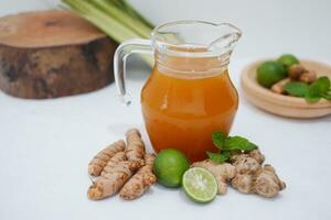 Ginger juice with fresh ginger and lemon on white background. Healthy drink. photo
