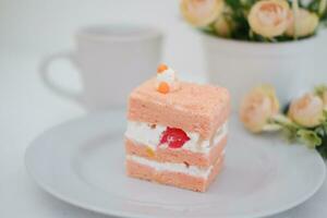 Piece of cake and cup of tea on white background, stock photo