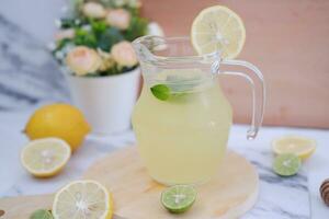 Lemonade with fresh lemon and mint leaves on a white background photo