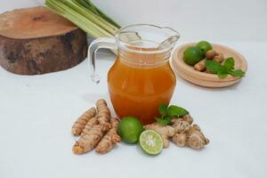 Ginger juice with fresh ginger and lemon on white background. Healthy drink. photo