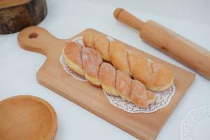 Bread donuts on the wooden table with wooden rolling pin. photo