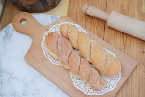 Bread donuts on the wooden table with wooden rolling pin. photo