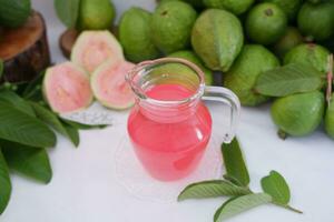 Fresh guava juice in a glass and fresh guava fruit. photo