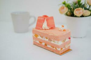 Piece of cake and cup of tea on white background, stock photo