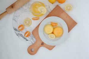 Orange jelly with fresh lemon and orange juice on a white background. photo