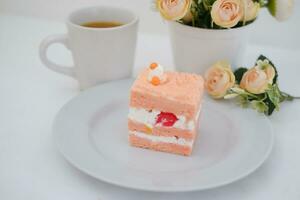 Piece of cake and cup of tea on white background, stock photo