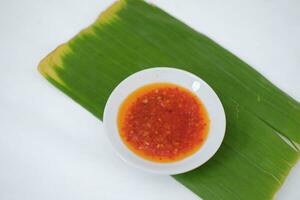 Thai style chili paste on banana leaf on a white background. photo