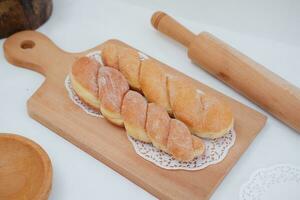 Bread donuts on the wooden table with wooden rolling pin. photo