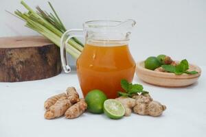 Ginger juice with fresh ginger and lemon on white background. Healthy drink. photo