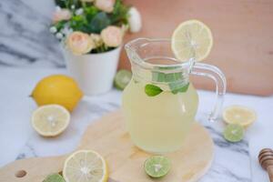 Lemonade with fresh lemon and mint leaves on a white background photo