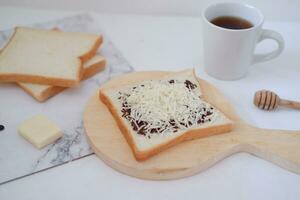 desayuno con café, queso y un pan en blanco mármol mesa. foto