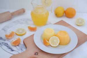 Orange jelly with fresh lemon and orange juice on a white background. photo