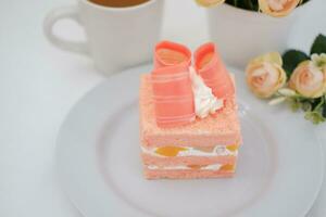 Piece of cake and cup of tea on white background, stock photo