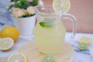 Lemonade with fresh lemon and mint leaves on a white background photo