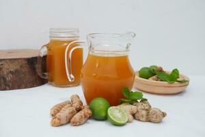 Ginger juice with fresh ginger and lemon on white background. Healthy drink. photo