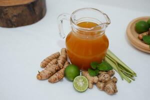 Ginger juice with fresh ginger and lemon on white background. Healthy drink. photo