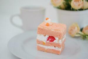 Piece of cake and cup of tea on white background, stock photo