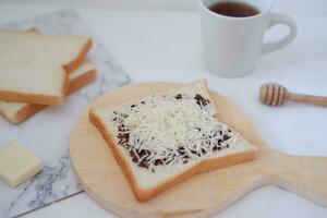 desayuno con café, queso y un pan en blanco mármol mesa. foto