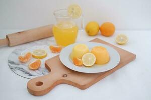 Orange jelly with fresh lemon and orange juice on a white background. photo