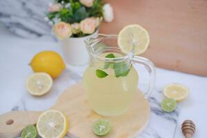 Lemonade with fresh lemon and mint leaves on a white background photo