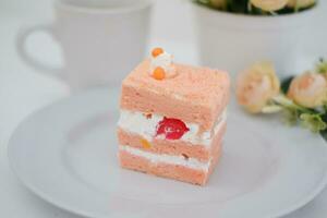 Piece of cake and cup of tea on white background, stock photo