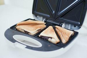 Toaster with toasted bread and chocolate in a white kitchen. photo