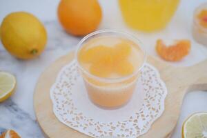 Fresh orange juice in glass and fresh citrus fruits on white background. photo