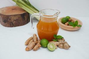 Ginger juice with fresh ginger and lemon on white background. Healthy drink. photo