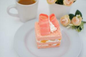 Piece of cake and cup of tea on white background, stock photo