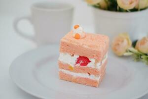 Piece of cake and cup of tea on white background, stock photo