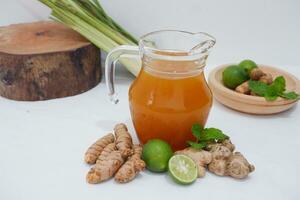 Ginger juice with fresh ginger and lemon on white background. Healthy drink. photo