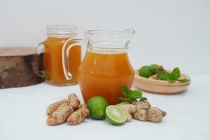 Ginger juice with fresh ginger and lemon on white background. Healthy drink. photo