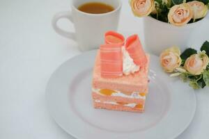 Piece of cake and cup of tea on white background, stock photo