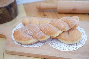 Bread donuts on the wooden table with wooden rolling pin. photo