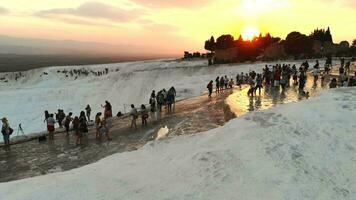 visitantes y turista personas camina de pamukkale calcio carbonato travertinos a puesta de sol video