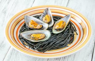 Black pasta with mussels photo
