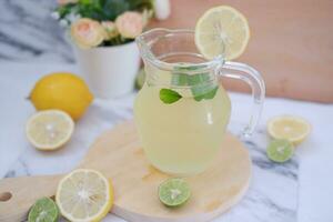 Lemonade with fresh lemon and mint leaves on a white background photo